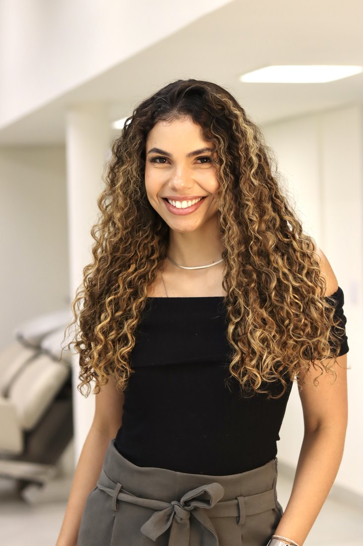 Cliente Reflora com cabelo longo cacheado